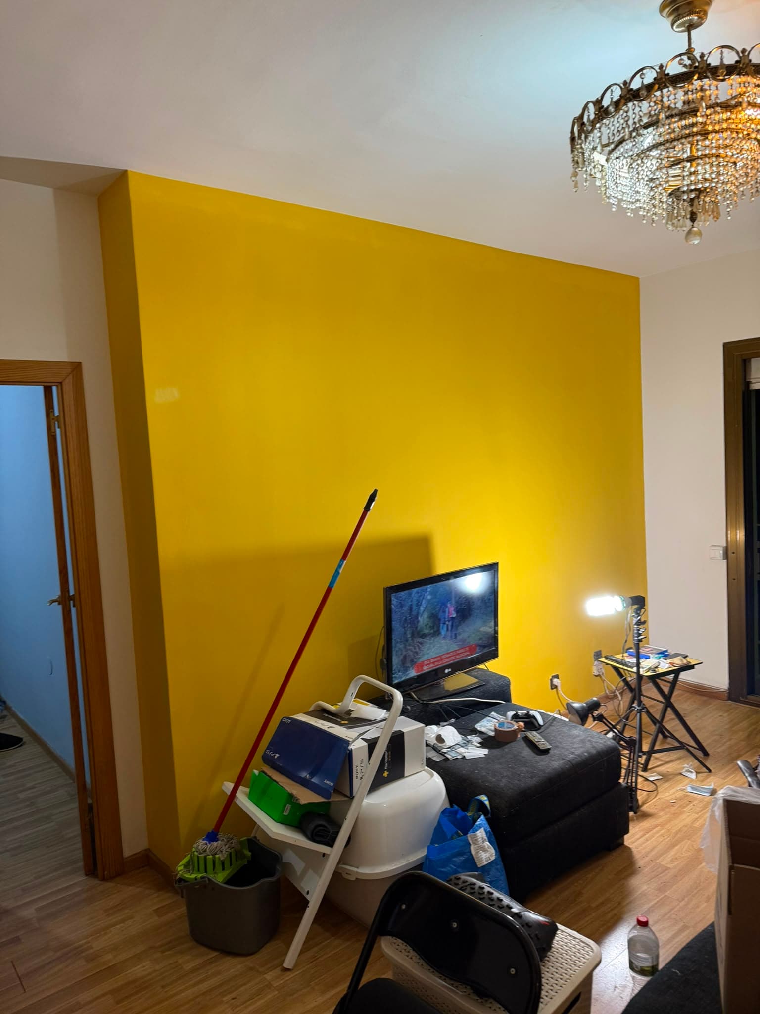 El mismo salón con la pared principal pintada en amarillo y el resto en blanco